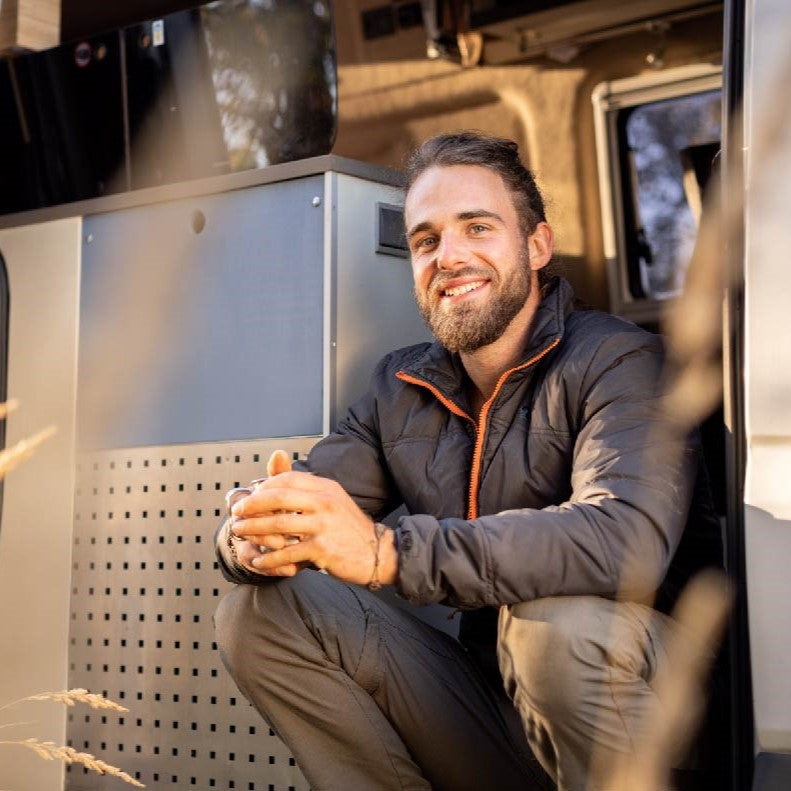 Mann sitzt in seinem Camper